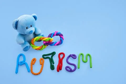 Blue teddy bear holding infinity symbol with autism word Foto stock