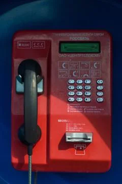 A blue telephone booth with a push-button corded telephone Stock Photos