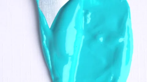 Blue texture close-up on a white background. Metal spatula smears liquid pa.. Stock Footage 271239413