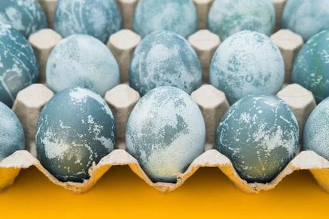 Blue textured colored Easter eggs on a bright yellow holiday background backd Stock Photos