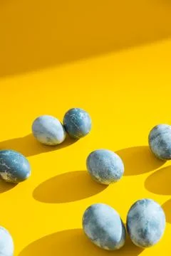 Blue textured colored Easter eggs on a bright yellow holiday background backd Stock Photos
