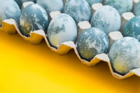 Blue textured colored Easter eggs on a bright yellow holiday background backdrop Stock-Fotos
