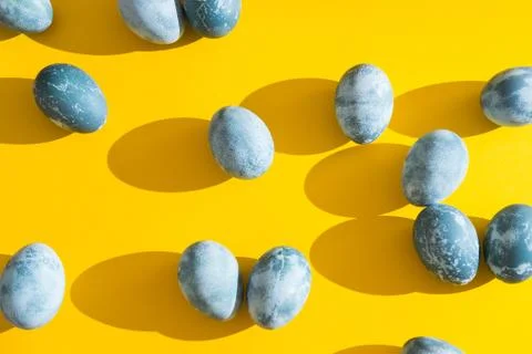Blue textured colored Easter eggs on a bright yellow holiday background backdrop Stock Photos