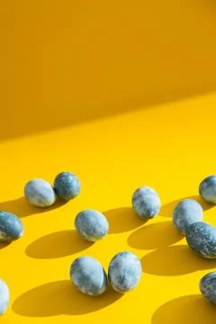 Blue textured colored Easter eggs on a bright yellow holiday background backdrop Stock Photos