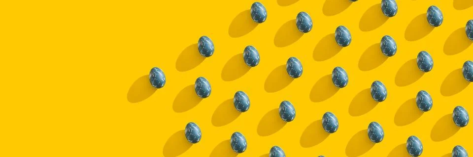 Blue textured colored Easter eggs on bright yellow holiday background backdrop Stock Photos