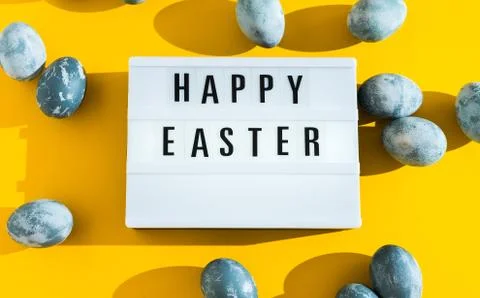 Blue textured painted Easter eggs and a luminous decorative board with the le Stock Photos