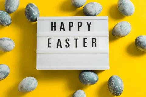 Blue textured painted Easter eggs and a luminous decorative board with the le Stock Photos