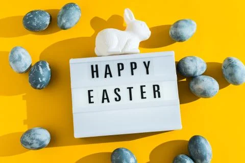 Blue textured painted Easter eggs, white plastic bunny and a luminous decorative Stock Photos