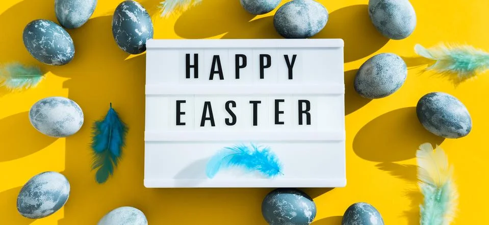 Blue textured painted Easter eggs, feathers and a luminous decorative board with Stock Photos