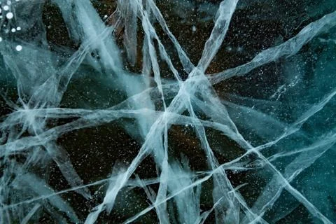 Blue thick layer of ice on a river with lots of cracks Stock Photos