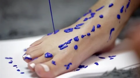 Blue thick paint drops on foot creating speckled dripping pattern on Stock Footage 277408121