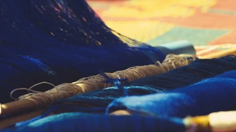 Blue thread being pulled and separated with wooden weight on the floor in Stock Footage 108448855