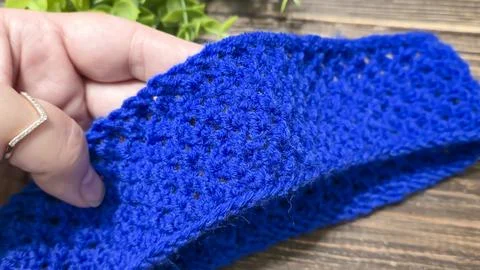 A blue thread pattern on a wooden background. Knitting tutorial and sample .. Stock Photos