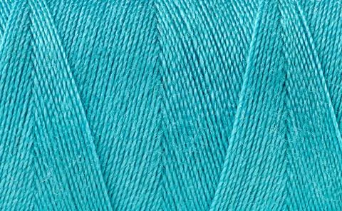 Blue thread spooled on a bobbin Stock Photos