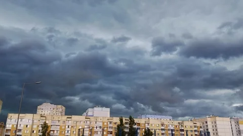 Blue thunderclouds over multi-storey buildings in the city. Bad weather before a Stock Footage 297849764