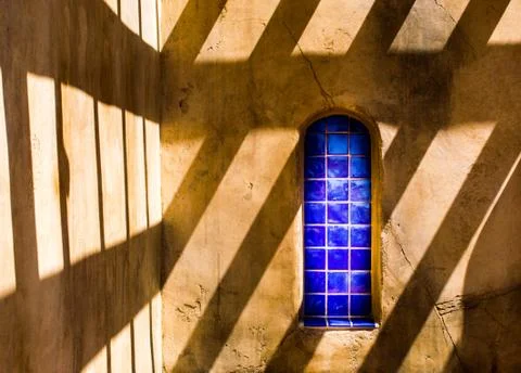Blue tile window in adobe building with shadows Stock Photos