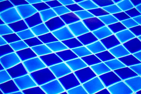 Blue tiled pool background with clear rippling water Stock Photos