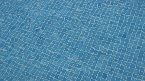 Blue tiled pool water with gentle ripples and reflections on a sunny day Stock Footage 319908043