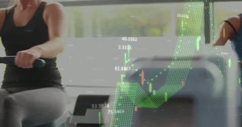 Blue-top rower reaching handle, pulling, checking screen while green graphs Stock Footage 334185551