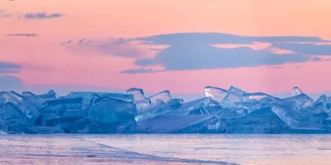Blue toros of Baikal against the background of the pink sky of the dawn and Stock Photos