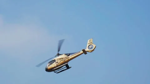 A blue tourist excursion helicopter taking off into a clear blue sky on a b.. Stock Footage 348284522