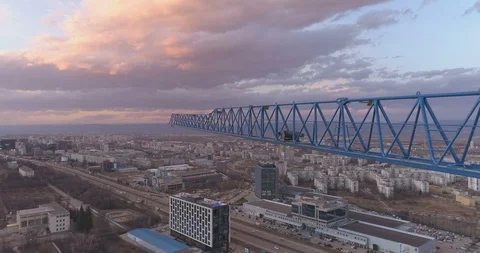 Blue tower crane arm on top of construction site. Sunset sky with fluffy Stock Footage 125522800