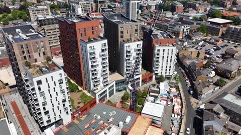 Blue tower crane rises over a residential development under construction, with 動画素材 343475221