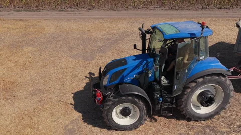 Blue tractor and grain trailer at edge of dry field, Aerial View Vídeos de archivo 346339927