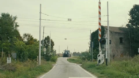 A blue tractor crosses an open grade crossing in the middle of the Stock Footage 208342978