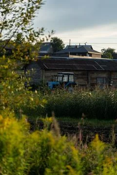 Blue tractor in the evening, at sunset after a hard day's work.A green field Stock Photos
