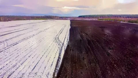 A blue tractor plows a field covered with snow. Watercolor illustration. Behi Stock Illustration