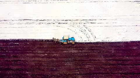 A blue tractor plows a field covered with snow. Watercolor illustration. Behi Stock Illustration