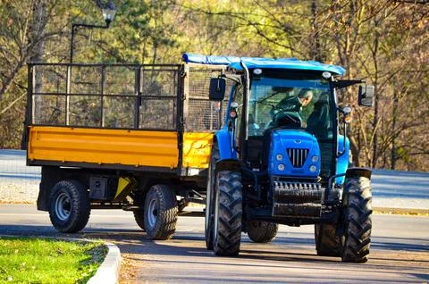 A blue tractor is pulling a yellow trailer. Foto stock