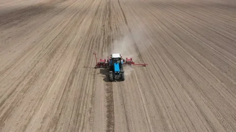 Blue tractor working on spring field, aerial view. Stock-Footage 130617145