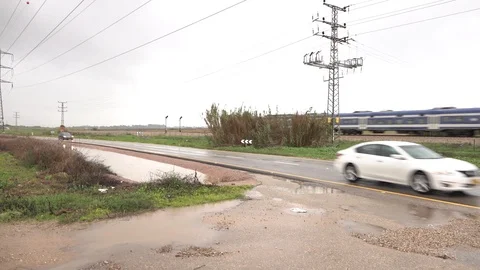 Blue train passes through rural areas on a rainy day Stock Footage 99577090