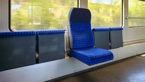  Blue train seat featuring checkered fabric pattern inside a public transit Stock Photos