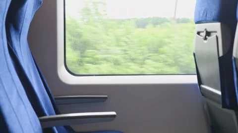 Blue train seats with dynamic landscape view through window during daytime .. Stock Footage 339581146
