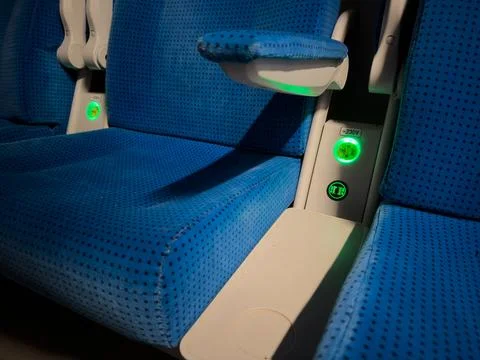 Blue train seats equipped with glowing green power outlets and USB charging Stock Photos