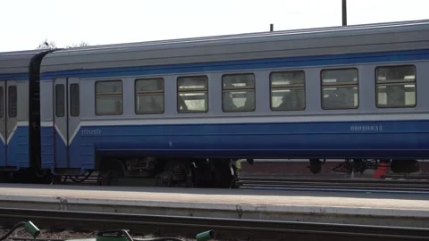 A blue train with white stripes rides along the peron Video stock 238021706