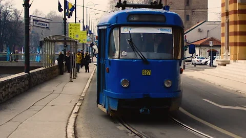 A blue tram is standing on traffic light in front of City Hall in Sarajevo. Video stock 152950136