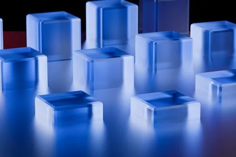 Blue translucent cubes arranged on a reflective surface under soft lighting. Illustrazione stock