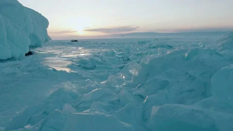 Blue transparent blocks of ice in the rays of sunset on the frozen Lake Baikal 库存影片 154745465