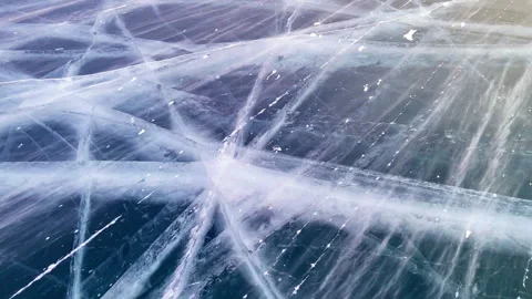 Blue transparent ice with deep cracks, top view of frozen lake. Stock Footage 248959487