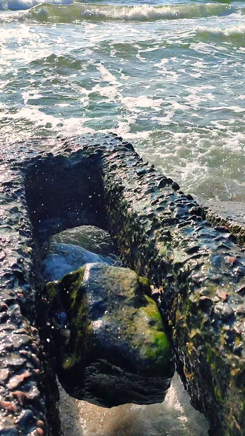 Blue transparent sea waves with white foam crashing against old concrete slabs Stock Footage 305993121