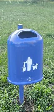 Blue trash can with an image of a man cleaning up after a dog Stock Photos