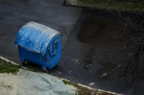 Blue trash can on the pavement Stock Photos