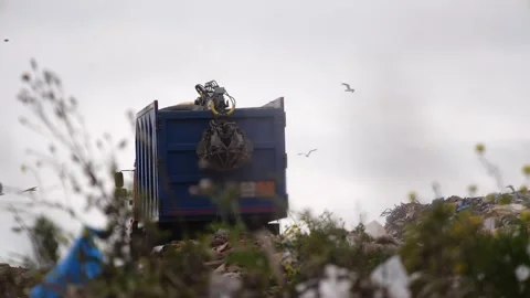 Blue truck full container of garbage goes through the dump. The dump truck  Stock-Footage 220747274