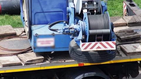 Blue truck-mounted winch system with cable spool and hydraulic mechanisms on Stock-Footage 342922614