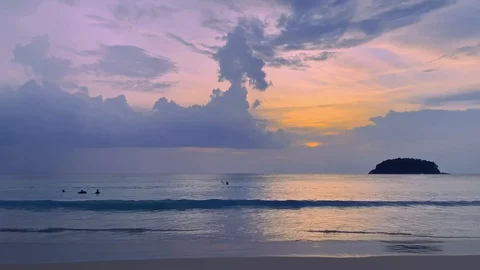 Blue twilight sunset sky on the beach with people swimming in sea and small Stock Footage 129079814