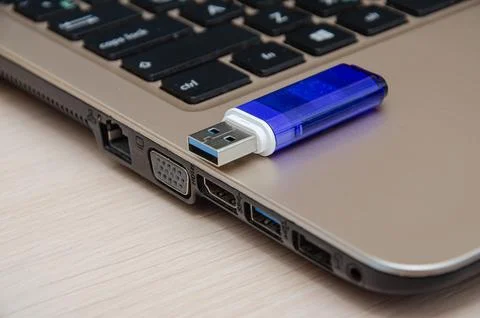 Blue USB flash drive connected to laptop computer's USB port. Notebook is on  Stock Photos